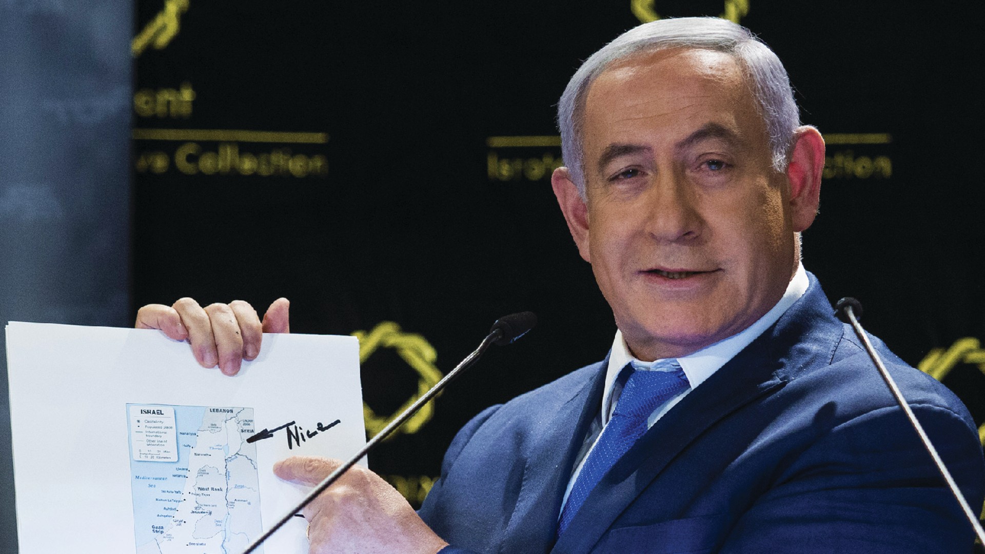 Israeli Prime Minister Benjamin Netanyahu points to a map of Israel that includes the Golan Heights and was signed by US President Donald Trump.