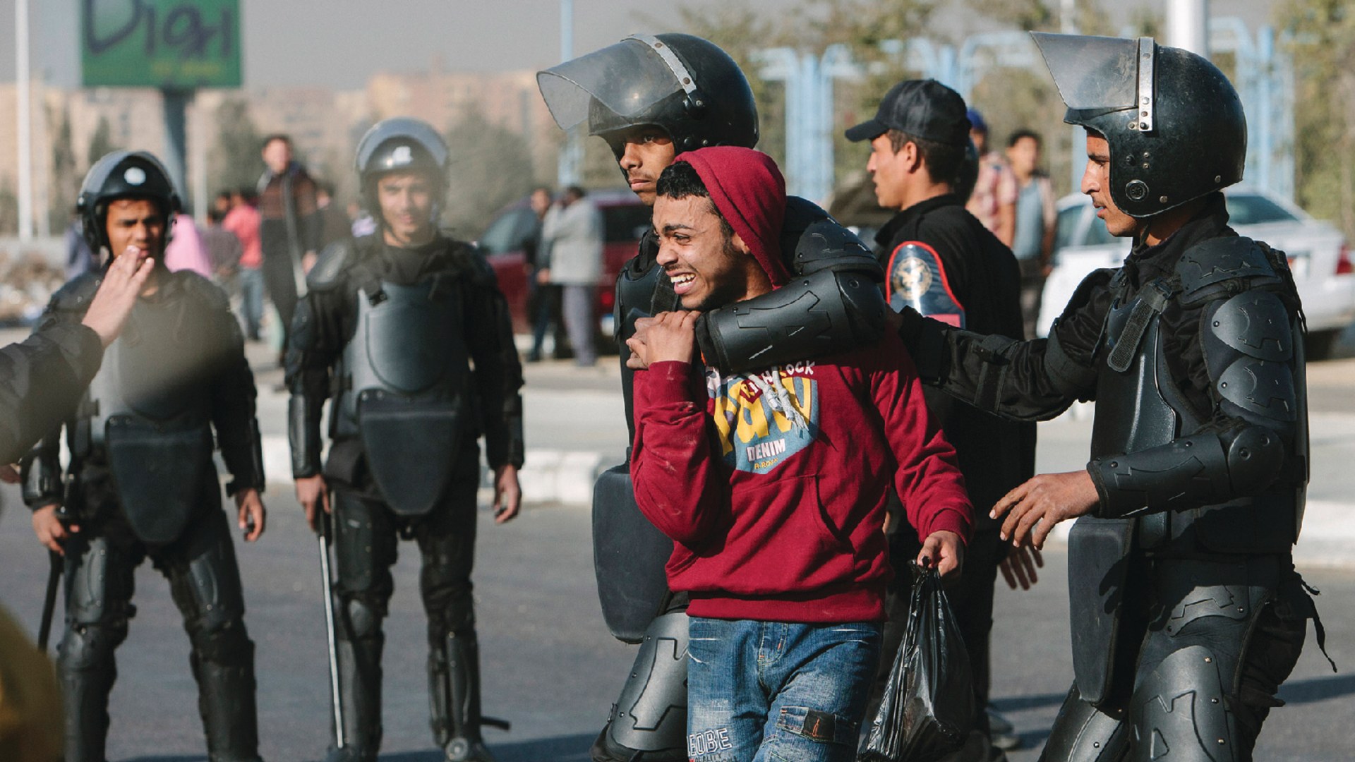 A Muslim Brotherhood supporter is arrested by Egyptian riot police in riot gear.