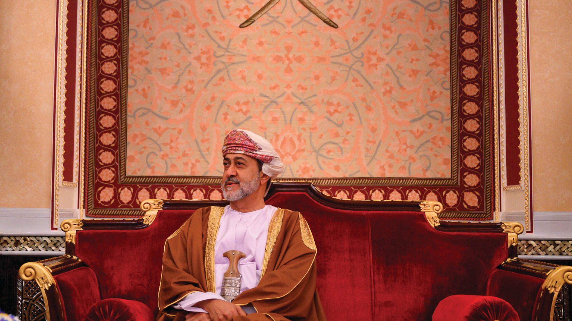 Oman’s monarch, Sultan Haitham bin Tariq, sits on a red couch at al-Alam palace in the capital city of Muscat, Oman.