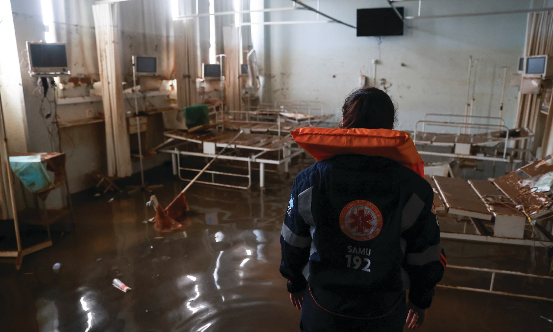 An emergency worker surveys a hospital emergency room destroyed by floods in Canoas, Brazil