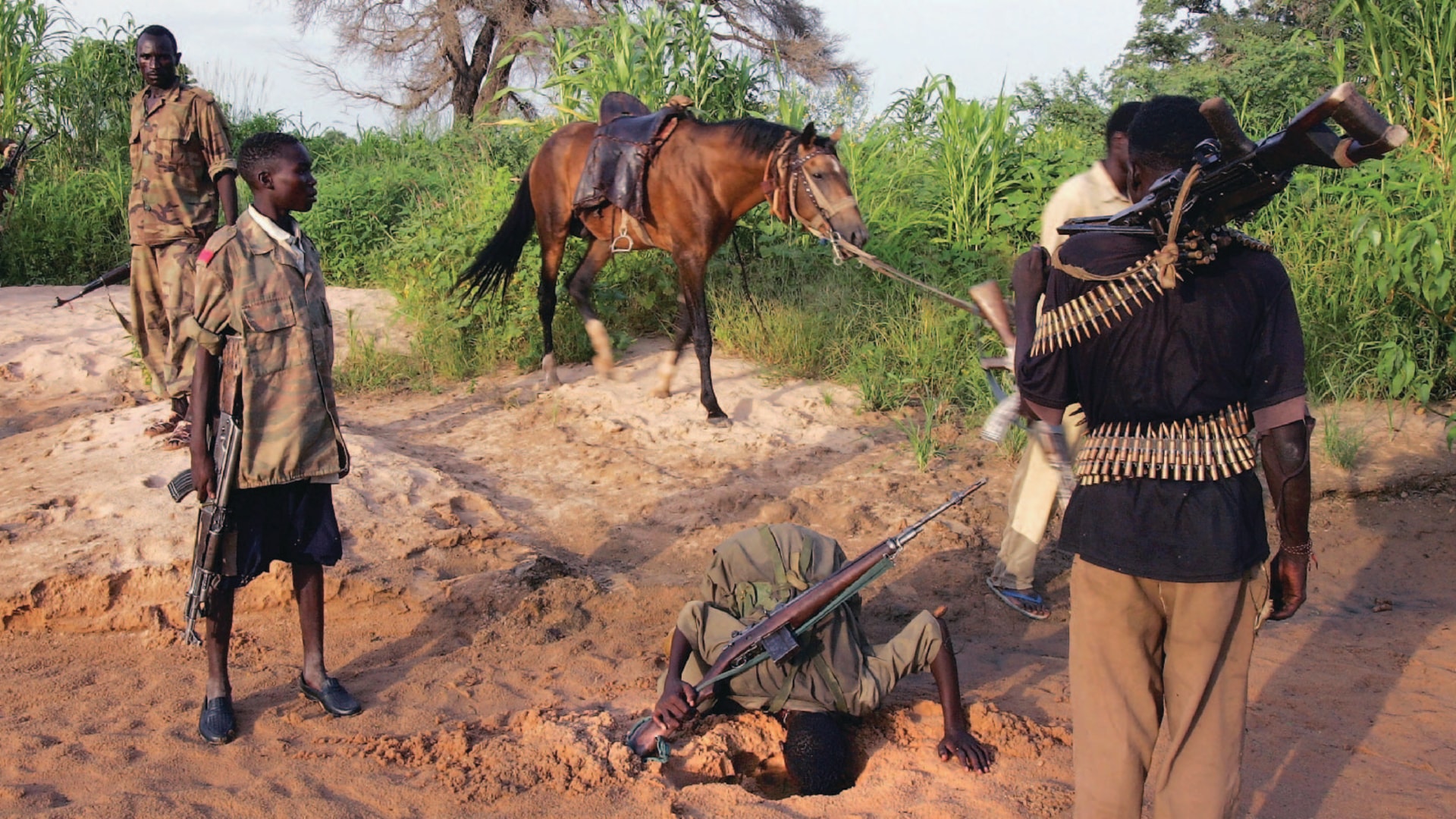 Rebel fighters from Sudan’s Justice and Equality Movement dig for water in a creek bed while patrolling near their base in Darfur, Sudan.