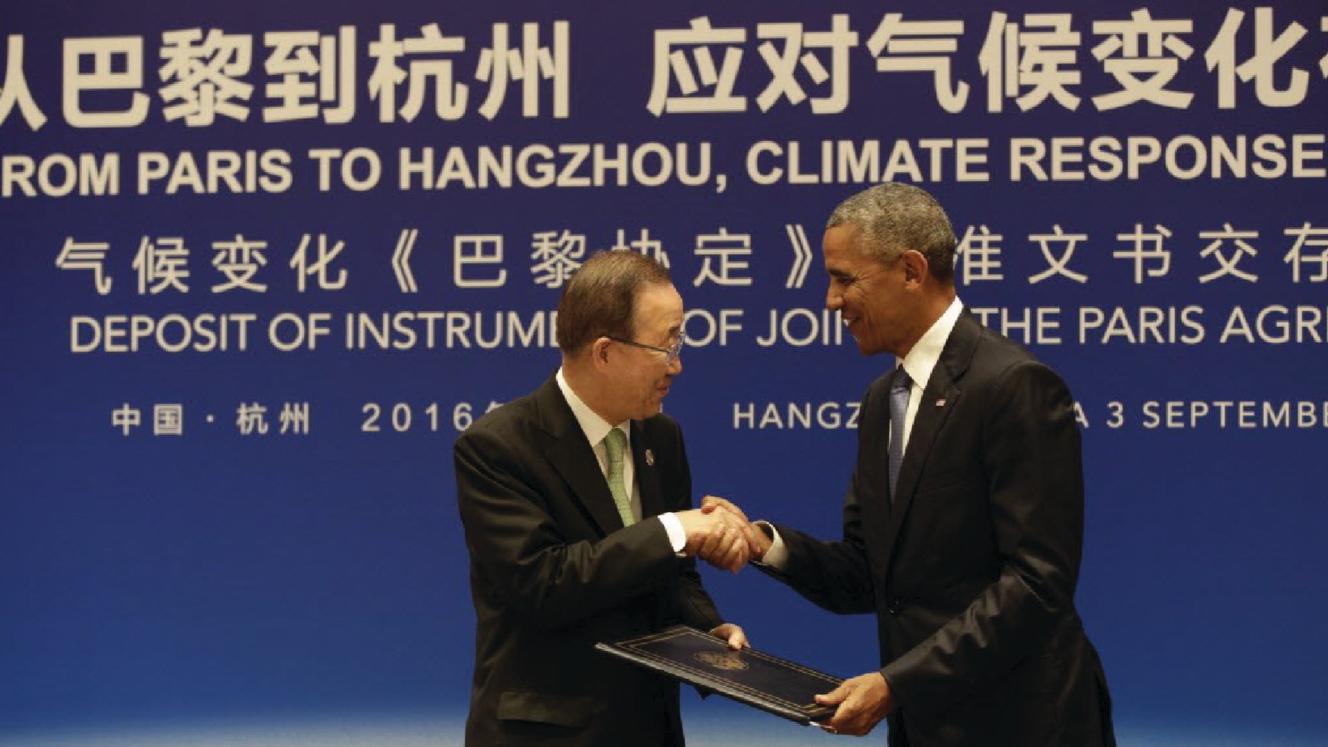 President Barack Obama hands the Paris Agreement documents to United Nations Secretary-General Ban Ki-moon during a climate event 