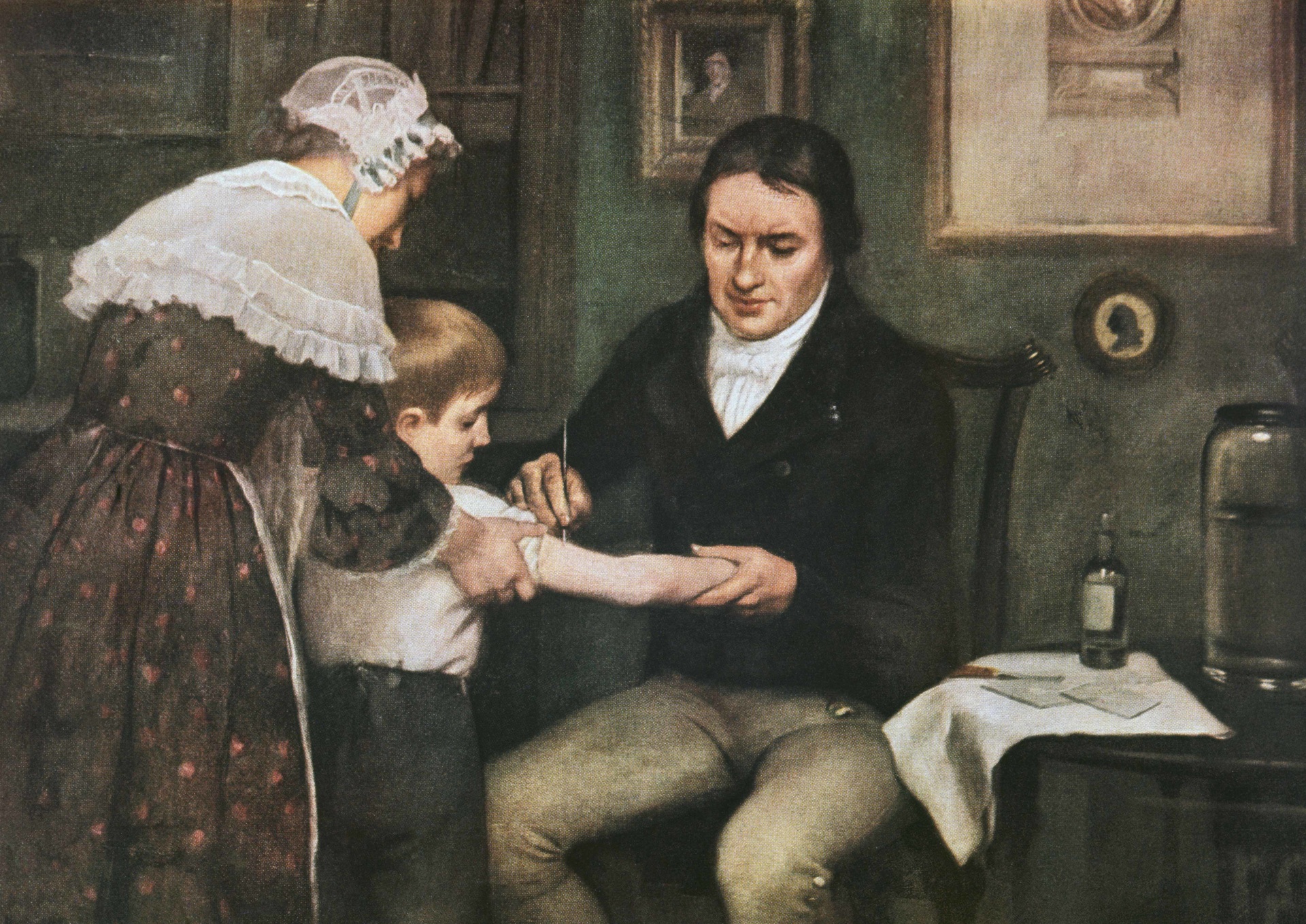 A painting of Dr. Jenner performing his first vaccination on a young boy as his mother holds him.