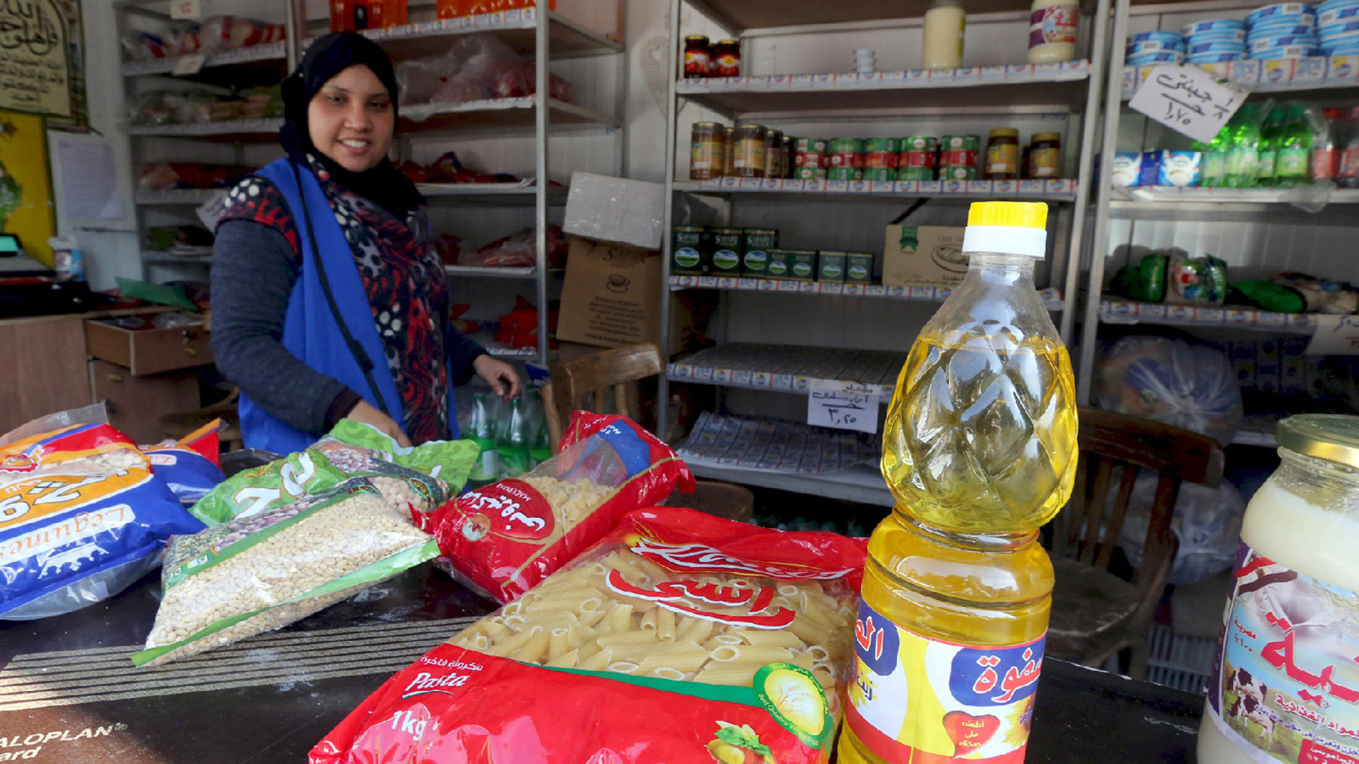 A worker sells subsidized food commodities, like oil, pasta, and various grains, at a government-run supermarket in Cairo, Egypt.