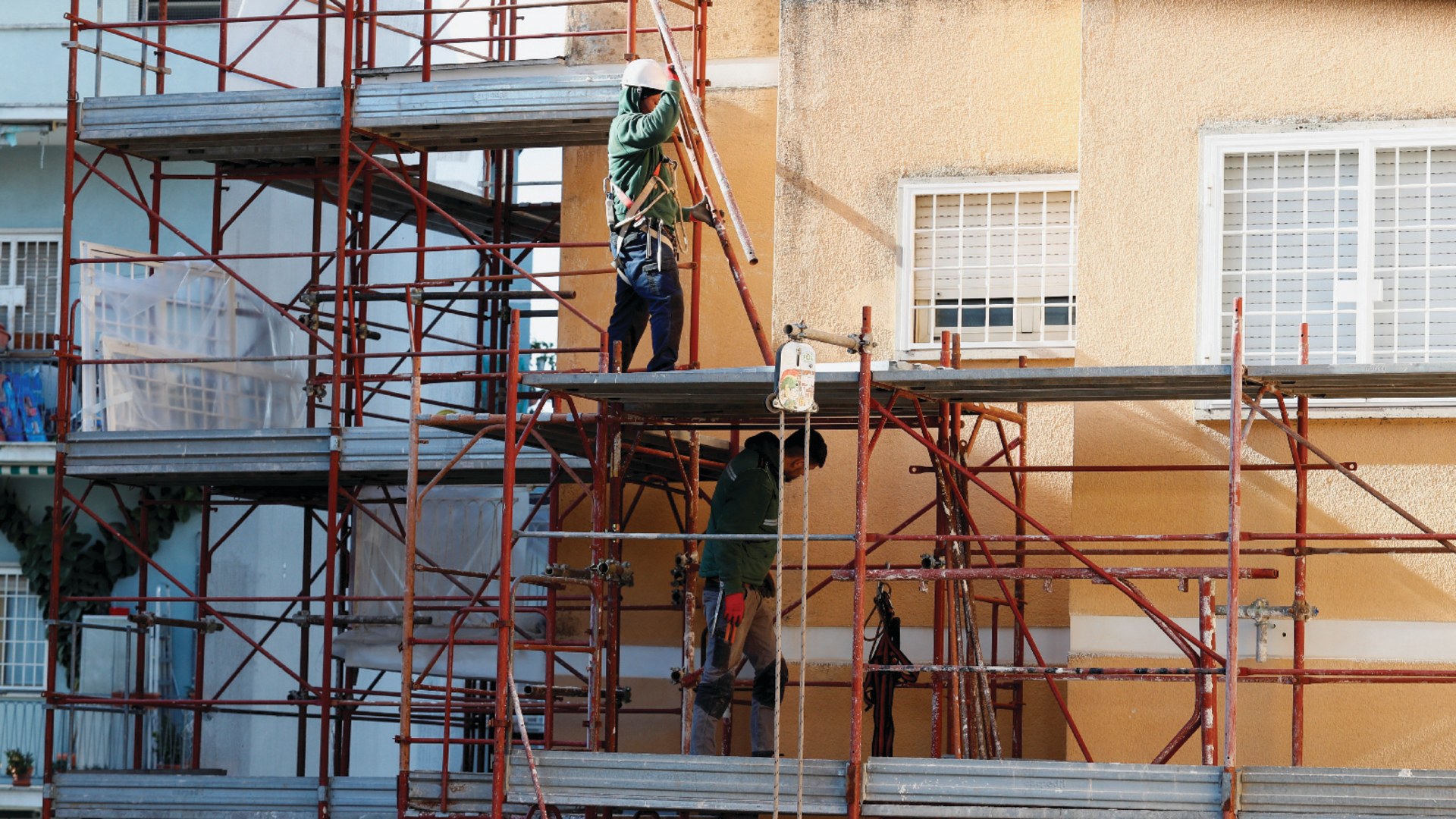 Builders work at the construction site of an energy-saving building in Rome, Italy, on February 1, 2023.