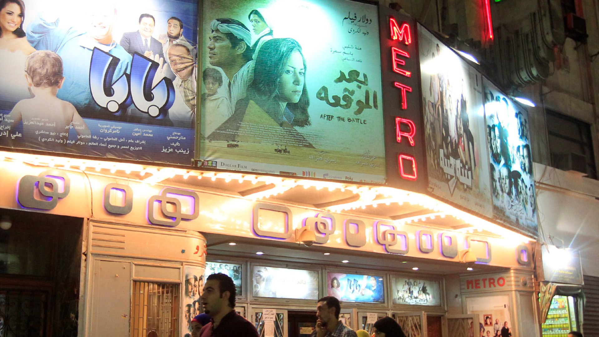 People walk past a cinema showing “After the Battle” a film about the one man’s experience in the aftermath of political rebellion in Cairo, Egypt on October 16, 2012.