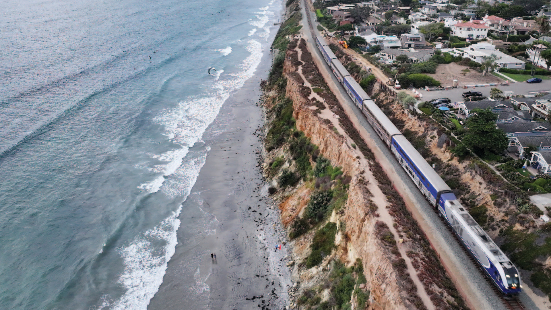 Amtrak train passing along the eroded Pacific coastline of Del Mar, California.