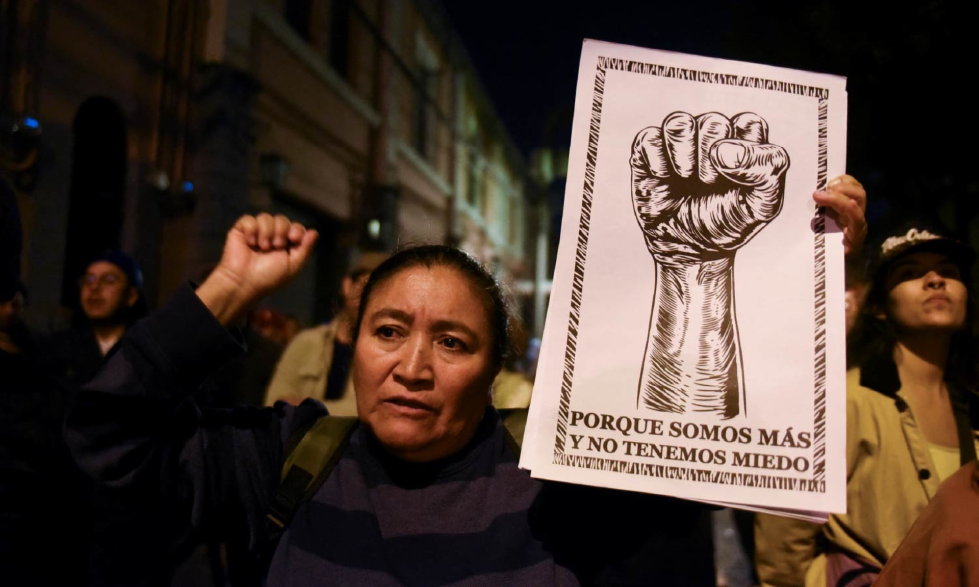 A woman holds up a sign that reads: ”because there are more of us and we are not afraid” at a speech by Guatemala's President Bernardo Arevalo.