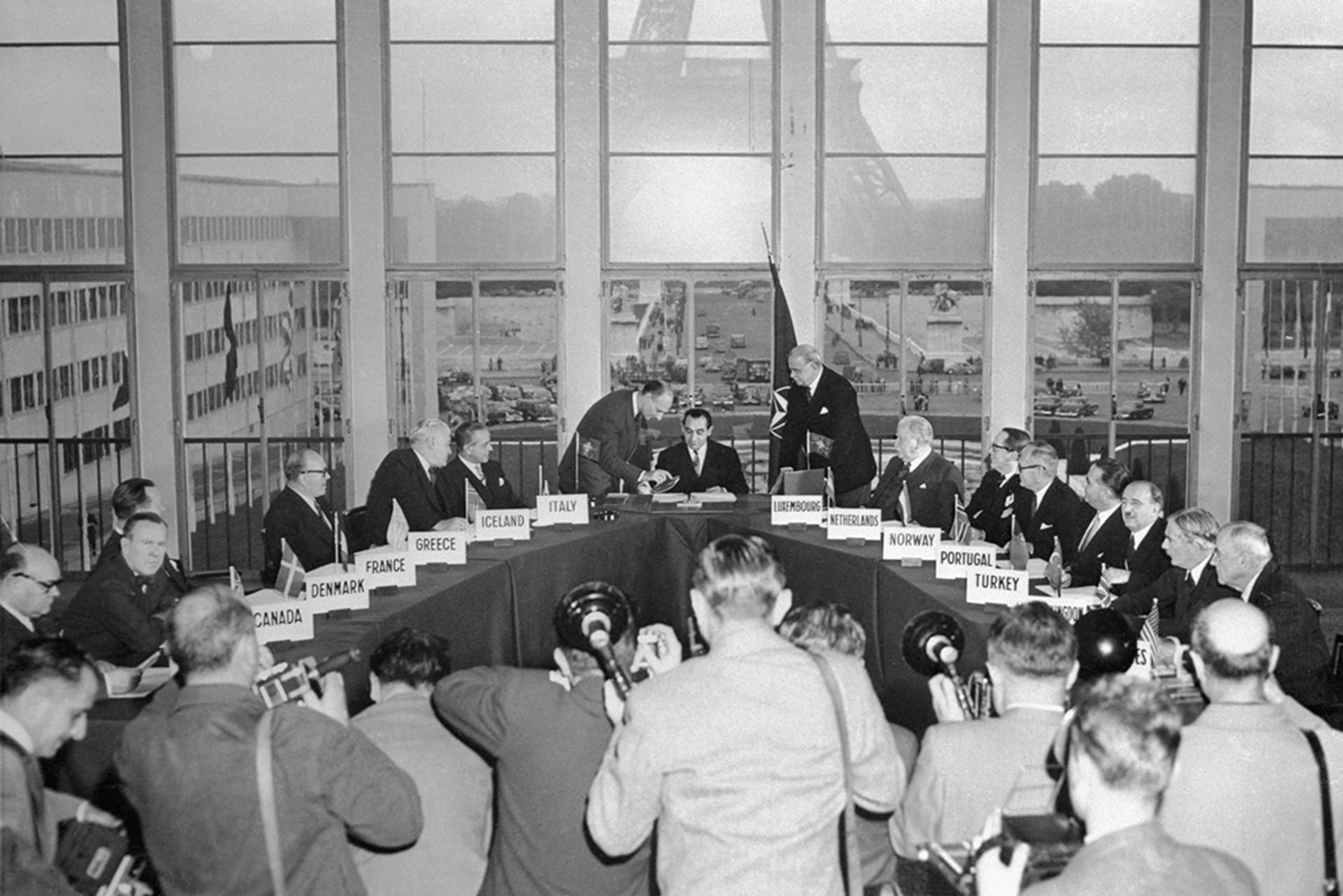 Foreign ministers from NATO counties look on as Pierre Mendes-France, the French foreign minister, signs the treaties making West Germany a part of NATO on October 22, 1954.