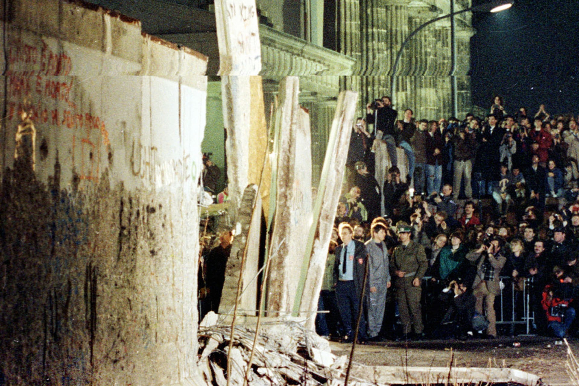 A big section of the Berlin Wall is lifted by a crane as East Germany starts to dismantle the wall near the Brandenburg Gate in East Berlin on February 20, 1990.