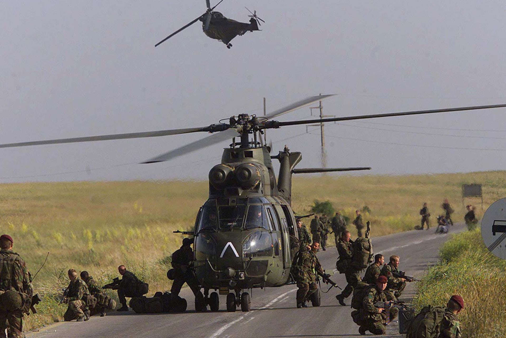British soldiers exit a helicopter after landing on the road near the southern Kosovo town of Kacanik on June 12, 1999.