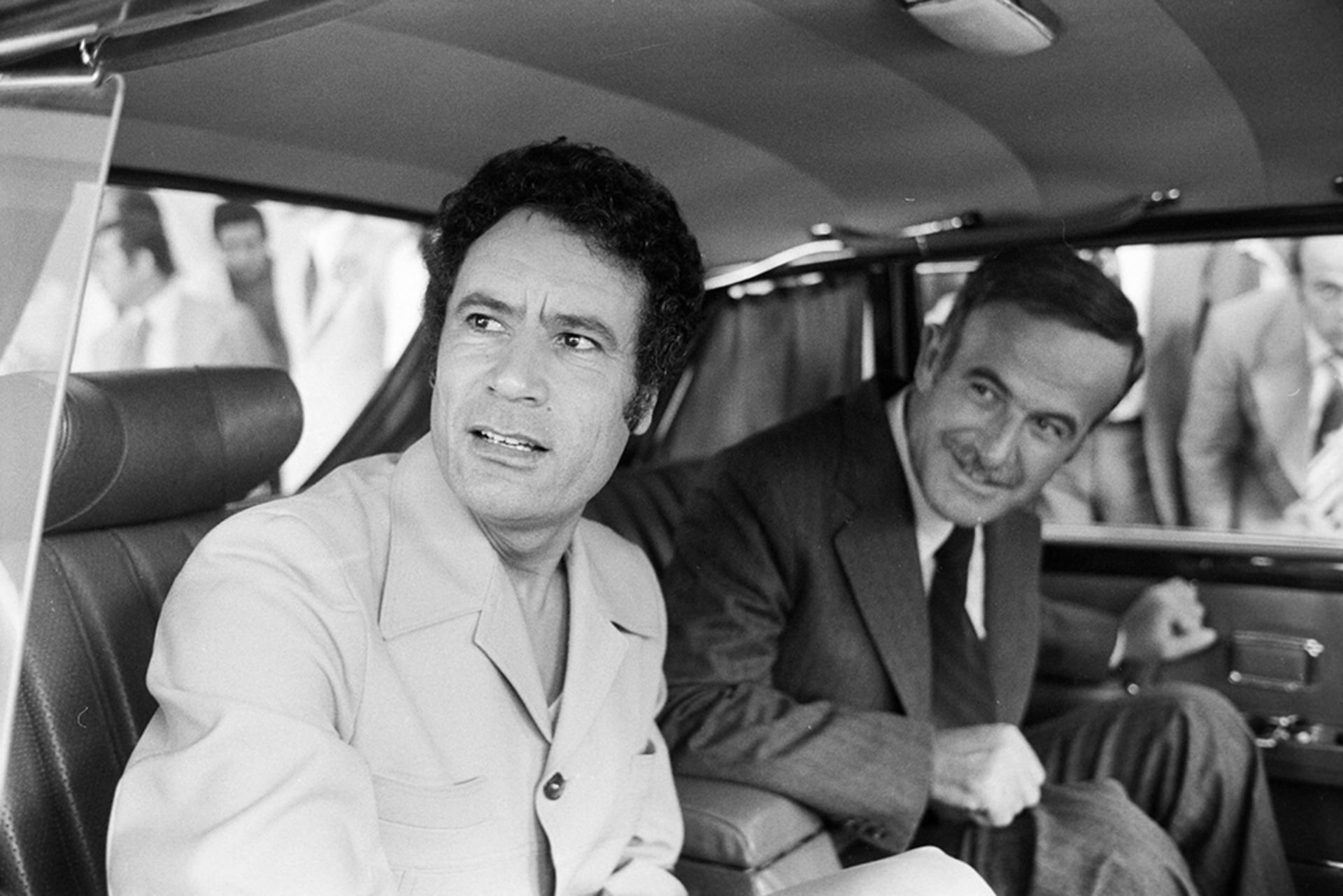 Libyan leader Muammar al-Qaddafi (left) and Syrian President Hafez al-Assad are seen in a car together during a conference of Arab leaders to oppose the Camp David Accords, in Damascus, on September 25, 1978.
