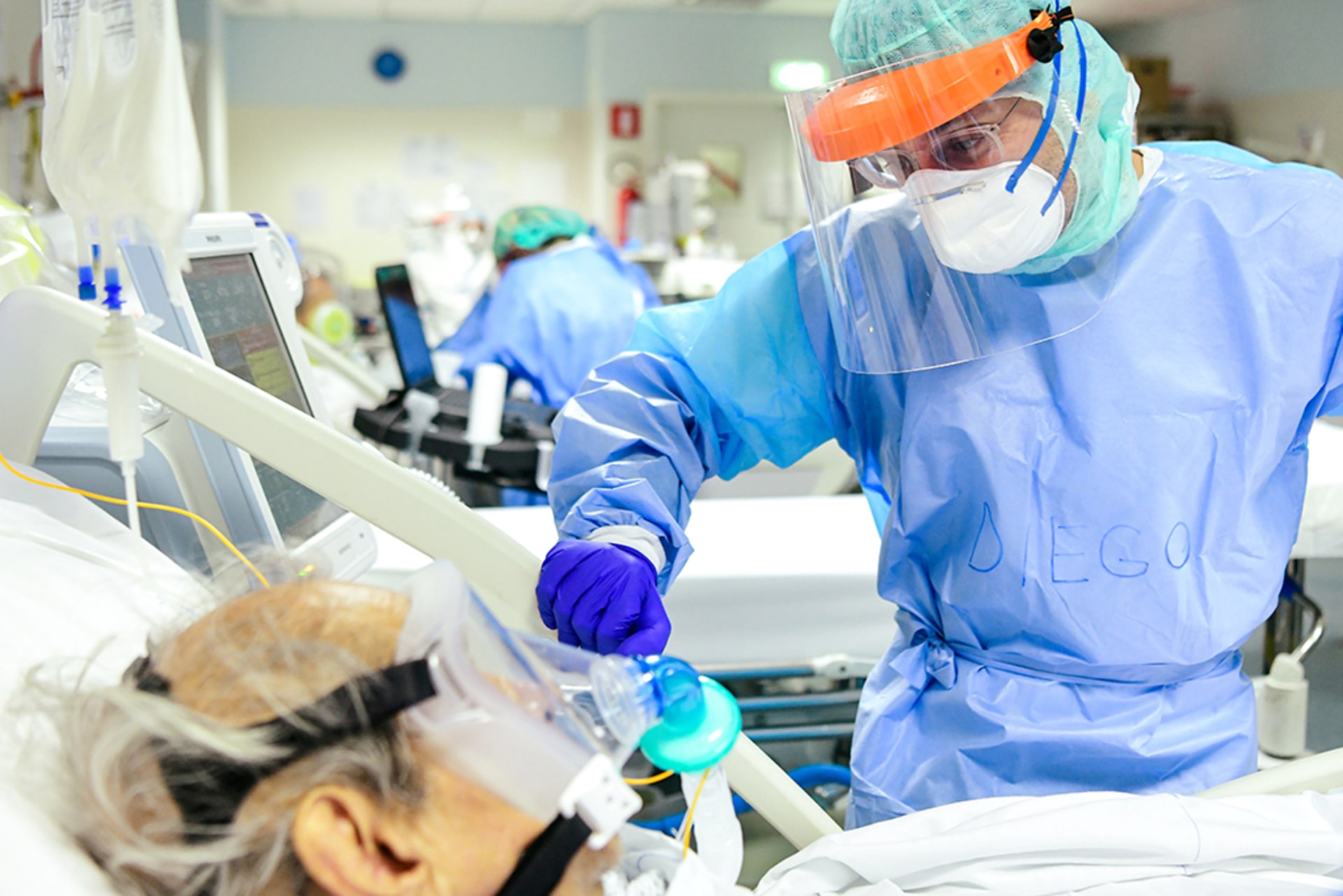 A member of the medical staff comforts a patient infected by the novel coronavirus at a hospital in Bergamo, Italy, on April 3, 2020.