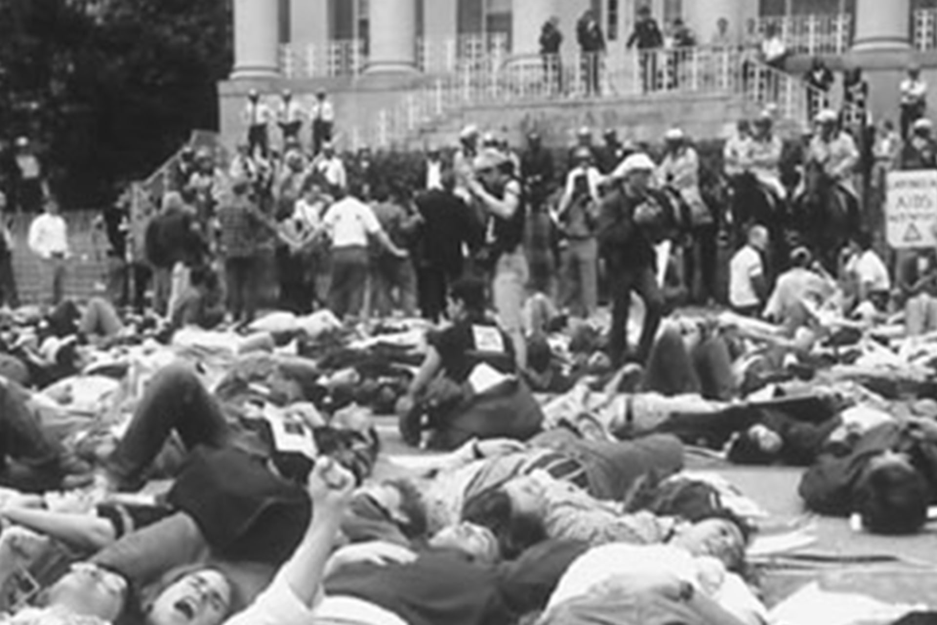 Protesters participate in a "die-in" by laying on the ground, motionless, at the National Institutes of Health campus during the "Storm the NIH" protest in Bethesda, Maryland on May 21, 1990.