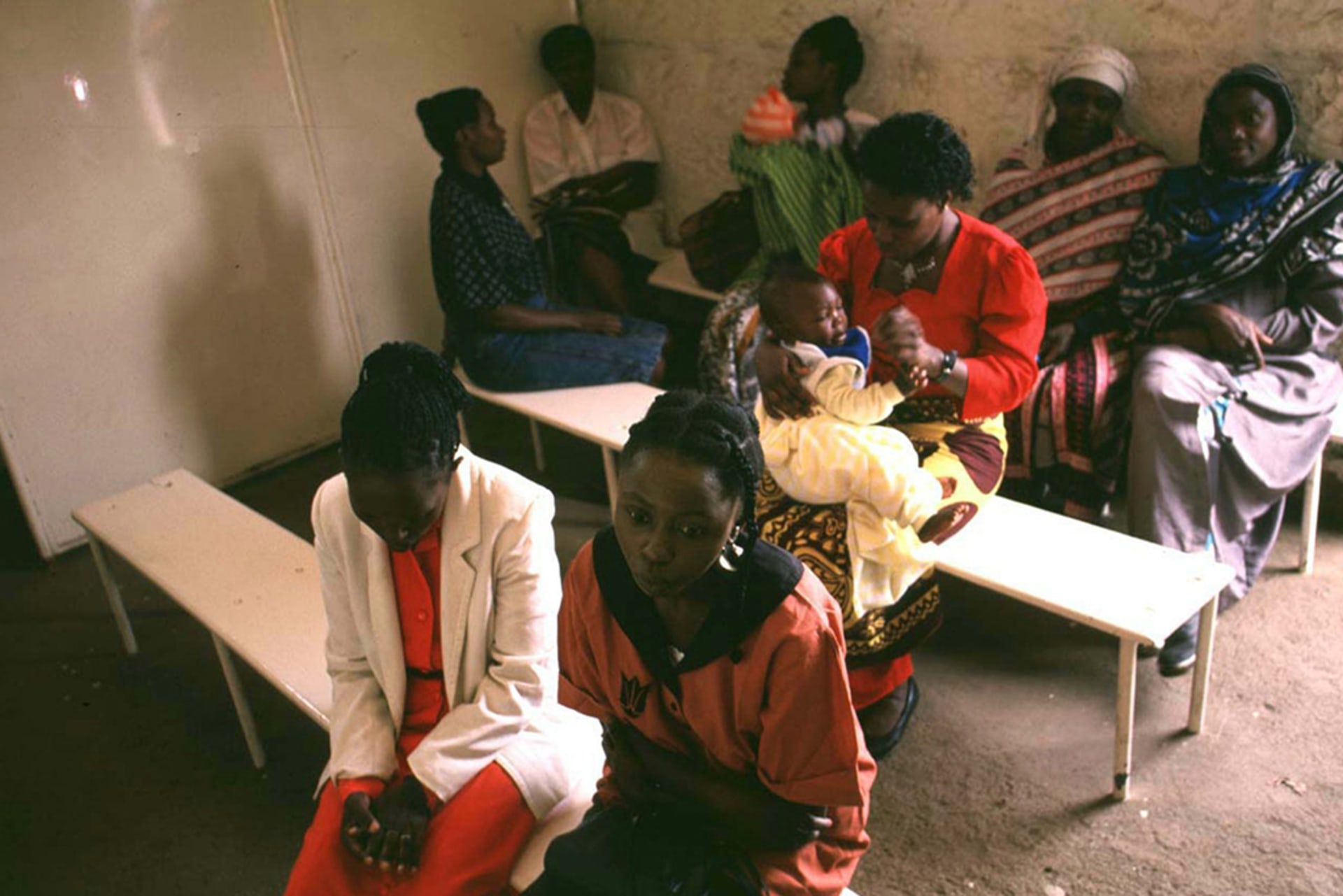 Sex workers wait, seated on benches, for tests at a clinic in the Majengo slum on the outskirts of Nairobi, Kenya, on October 6, 1997.