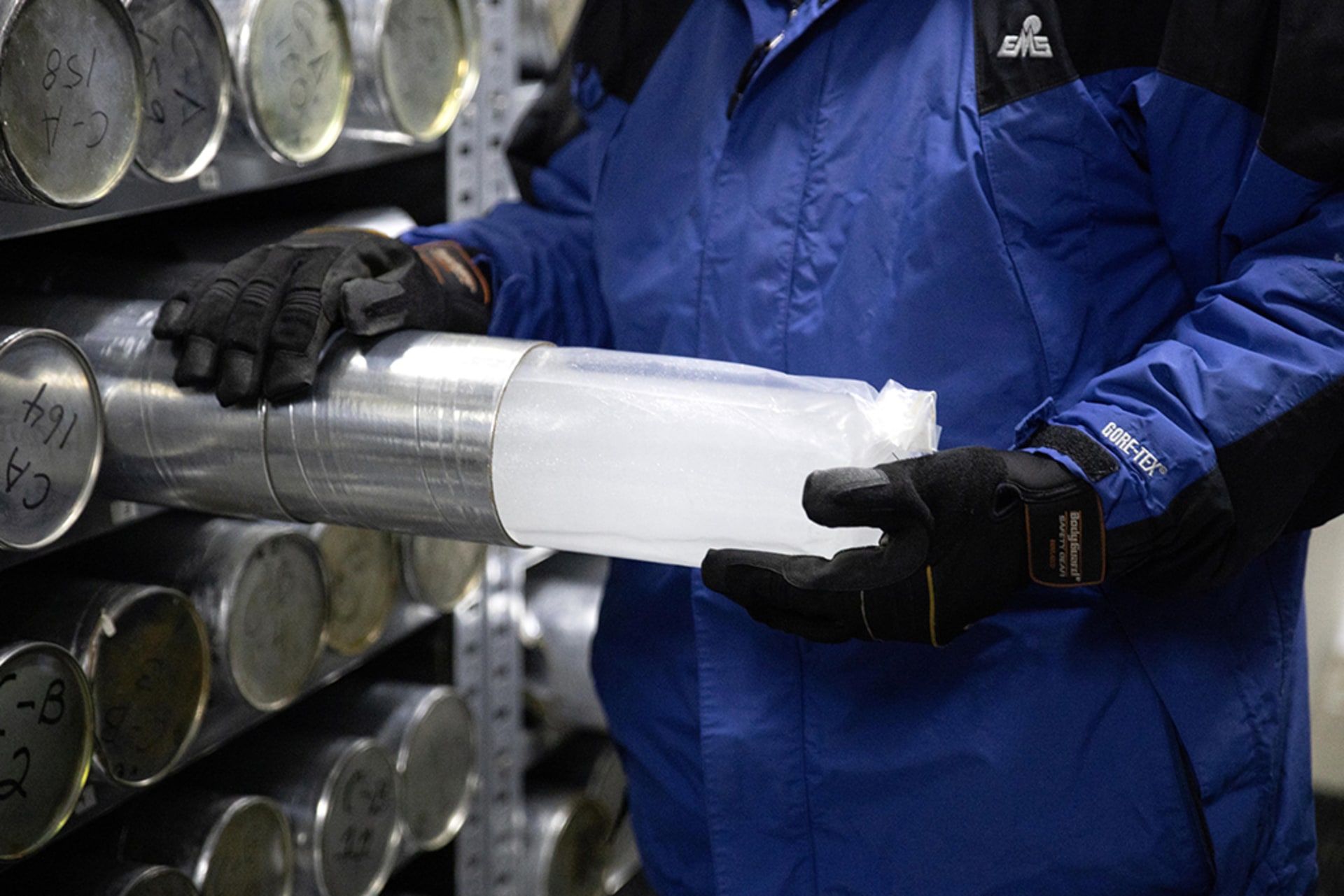 A scientist pulls a glacial ice core sample out of a metal tube on January 15, 2021.