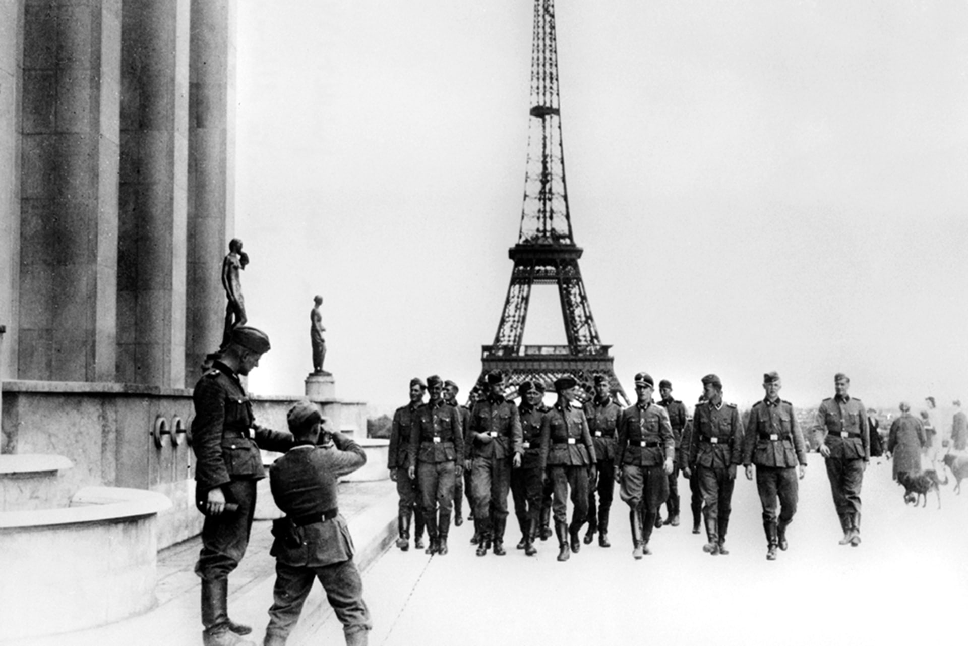 Nazi soldiers visit the Eiffel Tower in Paris in July 1940 as a man takes a picture of them.