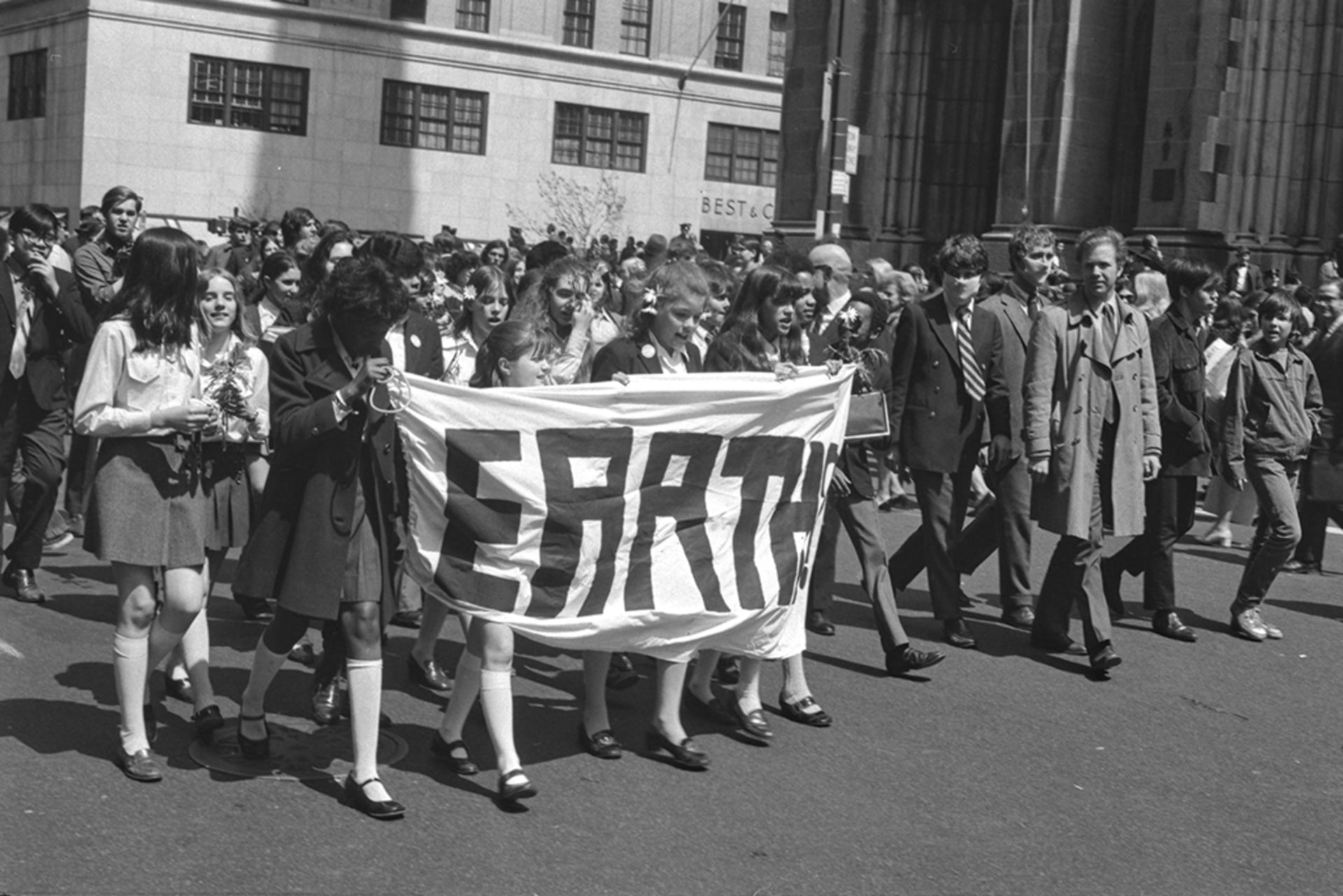 Earth Day celebration in Midtown, Manhattan, New York on April 22, 1970. People at the front hold a banner with the word "earth."