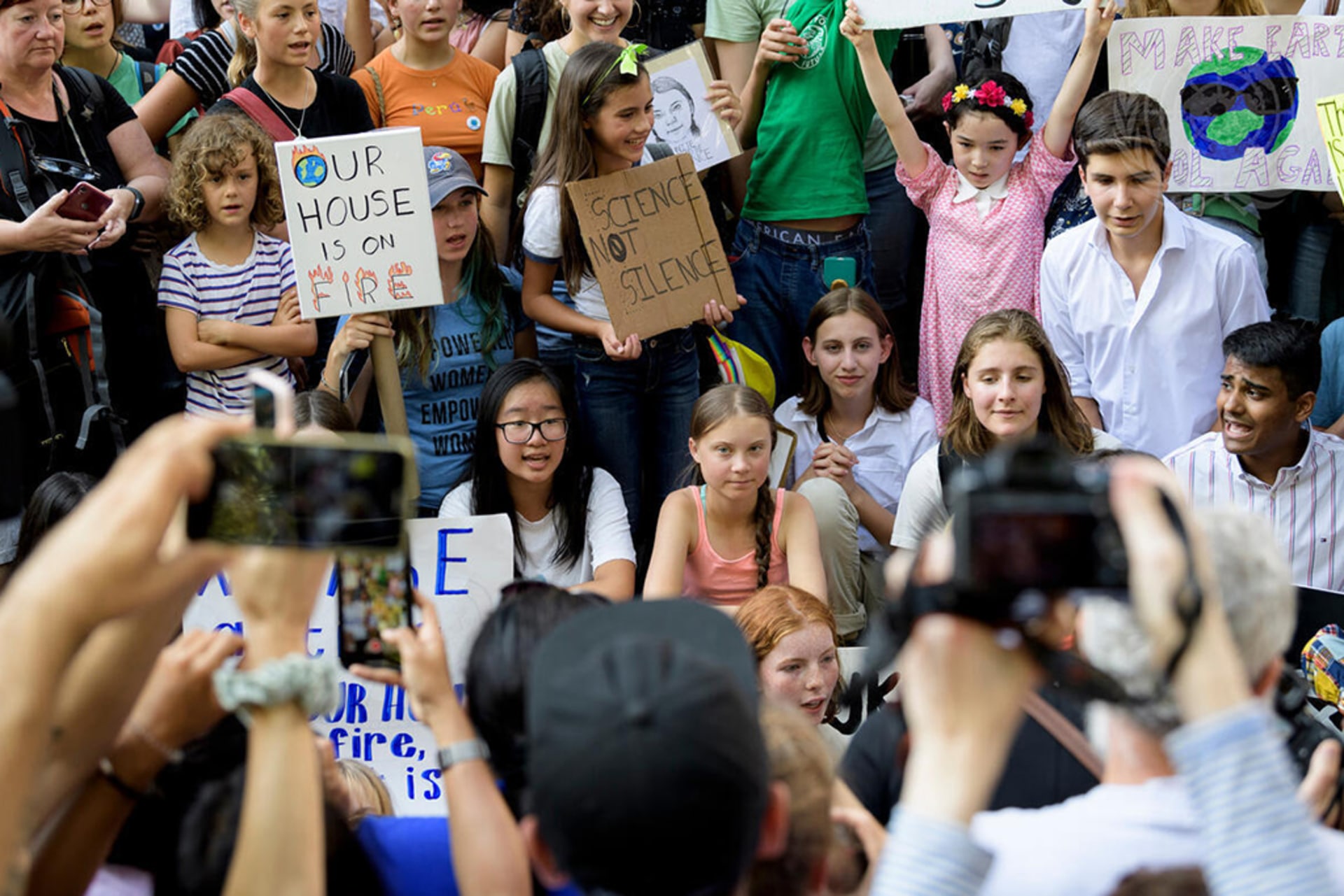Greta Thunberg sits in the center of young climate activists in a FridaysForFuture protest in front of the UN Headquarters.