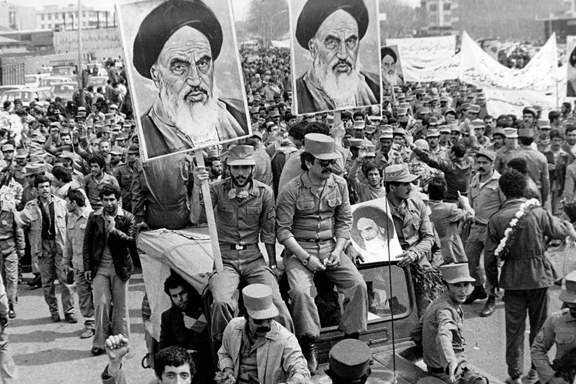 The Iranian Islamic Republic Army demonstrates in solidarity with people in the street during the Iranian revolution. They are carrying posters of the Ayatollah Khomeini, the Iranian religious and political leader.