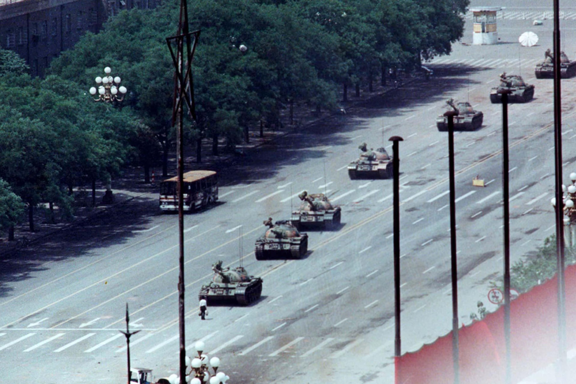 A man stands in front of a convoy of tanks in the Avenue of Eternal Peace in Tiananmen Square in Beijing, China.