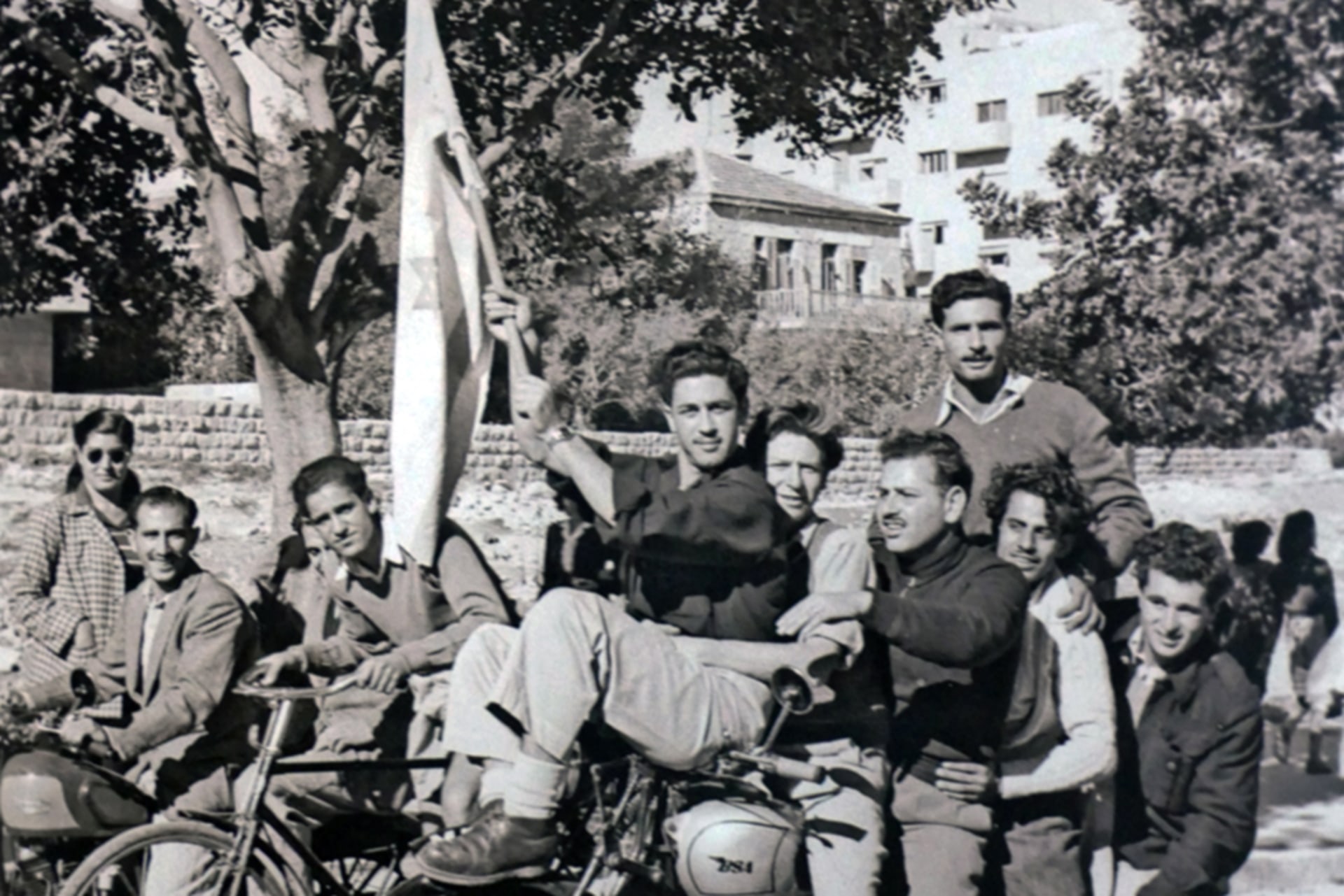 Jews in Jerusalem gathered together, on motorbikes, waving a flag and expressing joy after the UN adopted the Partition Plan.