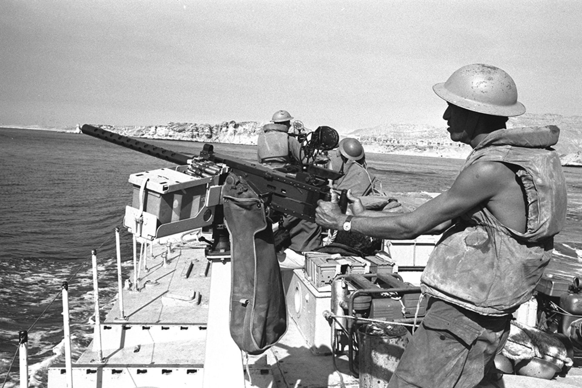 An Israeli gunboat passes through the Straits of Tiran near Sharm El Sheikh. A soldier stands holding his gun at the ready, facing the water.