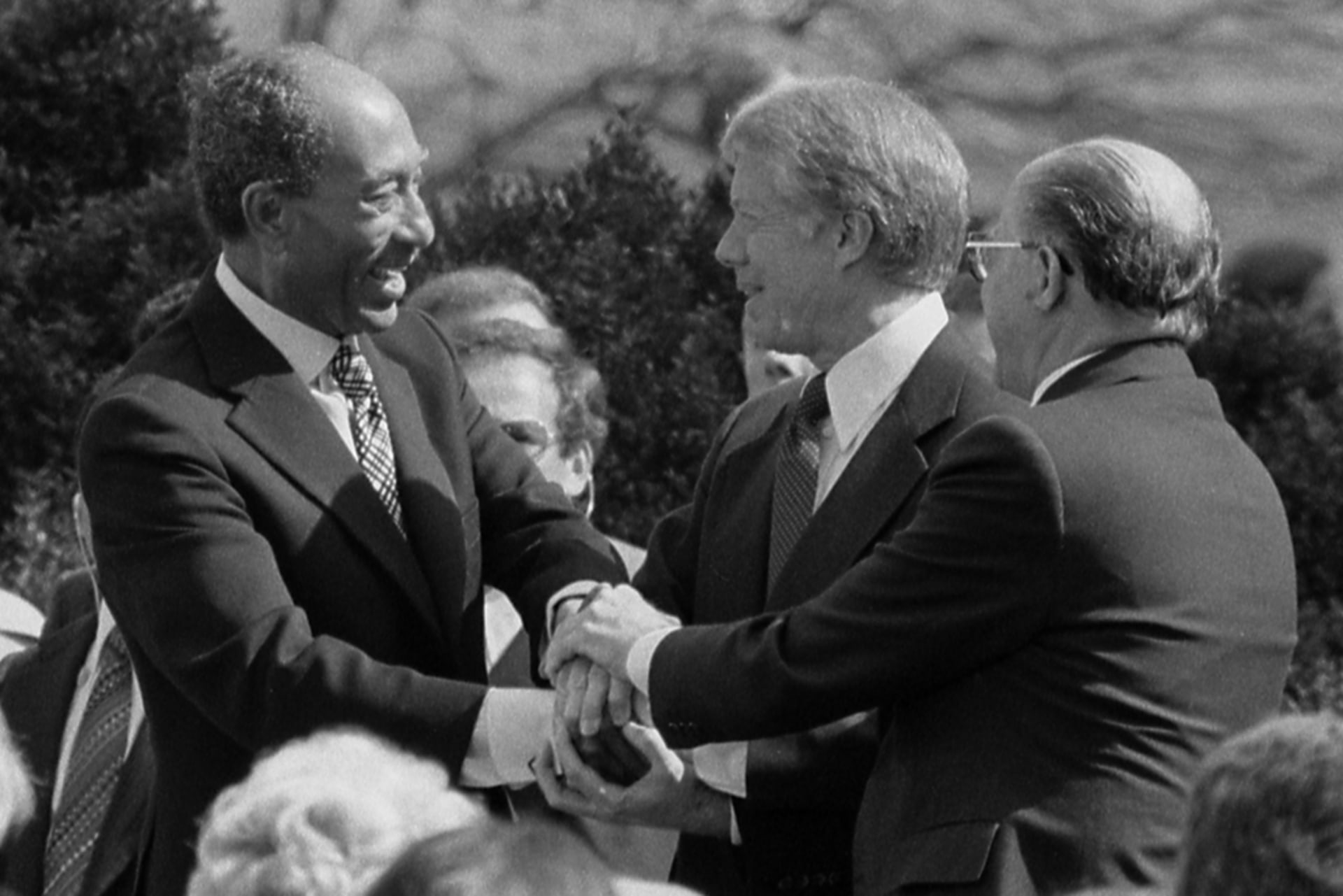 President Jimmy Carter shaking hands with Egyptian President Anwar Sadat and Israeli Prime Minister Menachem Begin at the signing of the Egyptian-Israeli Peace Treaty on the grounds of the White House.