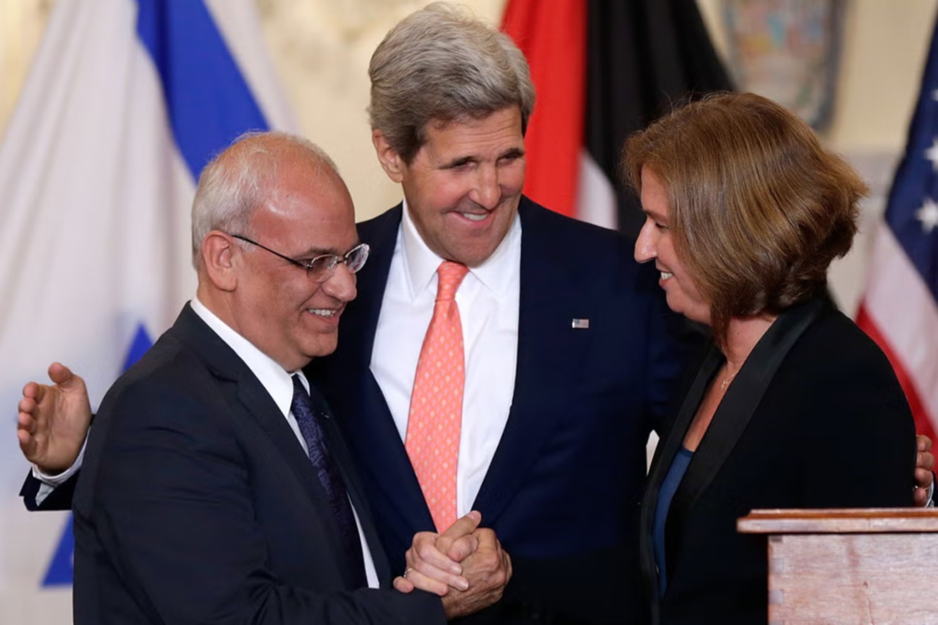 Chief Palestinian negotiator Saeb Erekat, U.S. Secretary of State John Kerry, and Israel's Justice Minister Tzipi Livni shake hands at a news conference at the end of talks at the State Department in Washington.