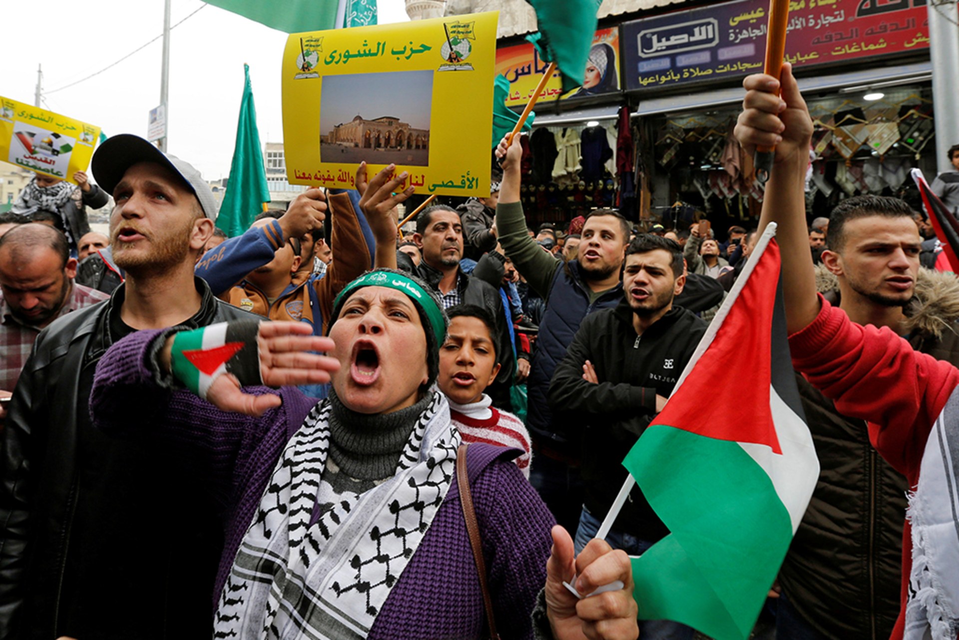 People chant slogans during a protest against U.S. President Donald Trump's recognition of Jerusalem as Israel's capital. A woman in the center yells out with a Palestinian flag in her hand.