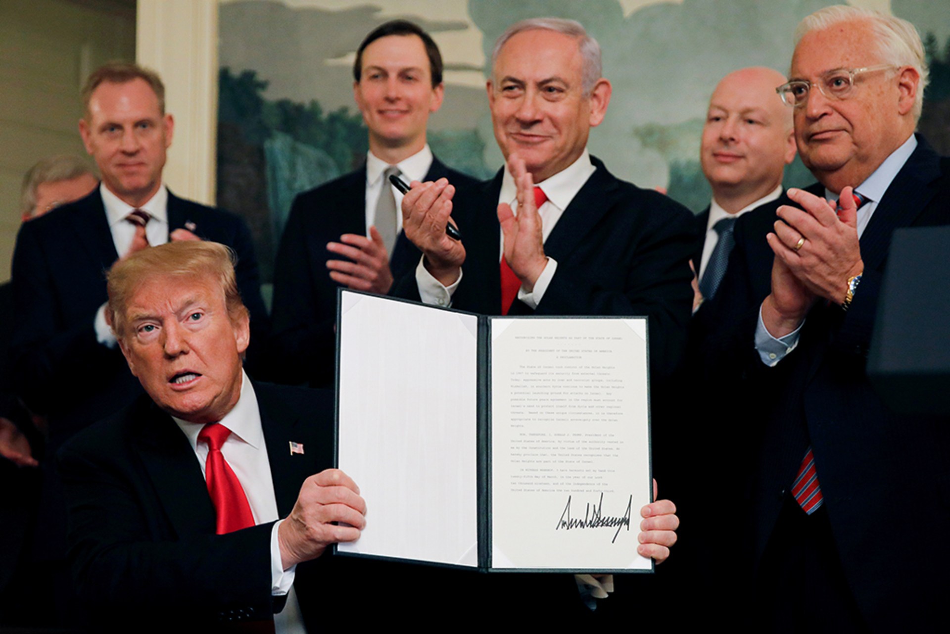 U.S. President Donald Trump holds a proclamation recognizing Israel's sovereignty over the Golan Heights as he is applauded by Israel's Prime Minister Benjamin Netanyahu and others during a ceremony in the Diplomatic Reception Room at the White House.