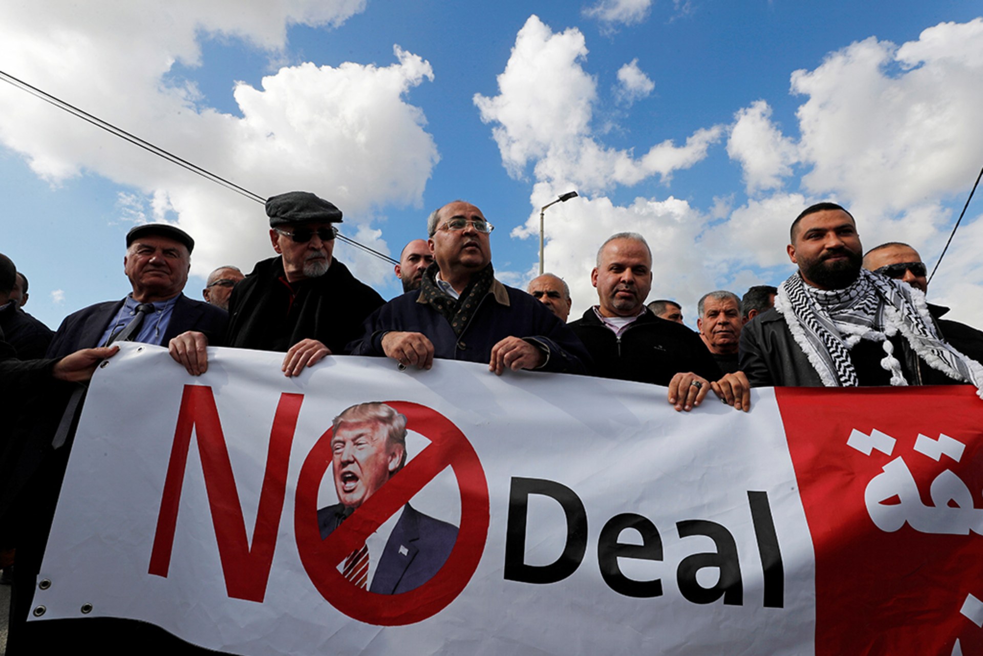 Parliament Member Ahmad Tibi from the Joint List Party takes part in a protest against former U.S. President Donald Trump's Middle East peace plan. The protestors each hold a part of a large banner stating "No Deal" with former President Trump's face.