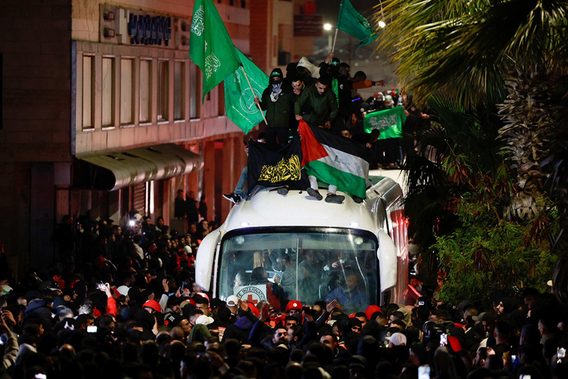 People gather around a bus carrying freed Palestinian prisoners after their release from an Israeli jail as part of a hostages-prisoners swap and a ceasefire deal in Gaza between Hamas and Israel, on January 20, 2025.