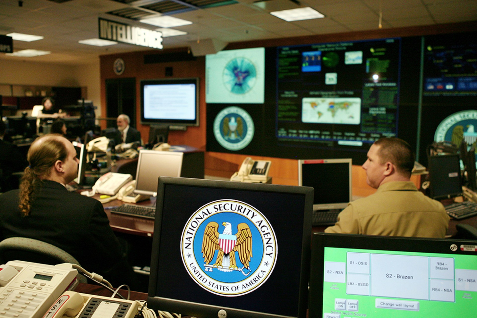 The National Security Agency (NSA) logo is shown on a computer screen inside the Threat Operations Center at the NSA in Fort Meade, Maryland. Various other screens are displayed.