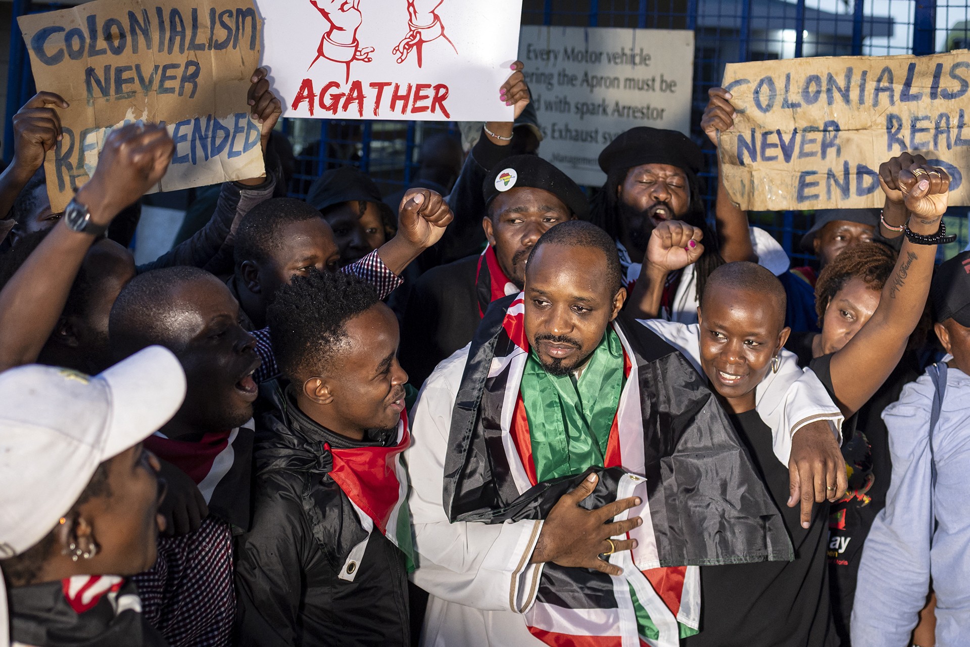 Kenyan journalist and human rights activist Boniface Mwangi (C) embraces his wife Njeri Mwangi as he reacts to a welcome by supporters and activists following his release from detention by Tanzanian authorities at the Wilson Airport in Nairobi on May 22, 2025.