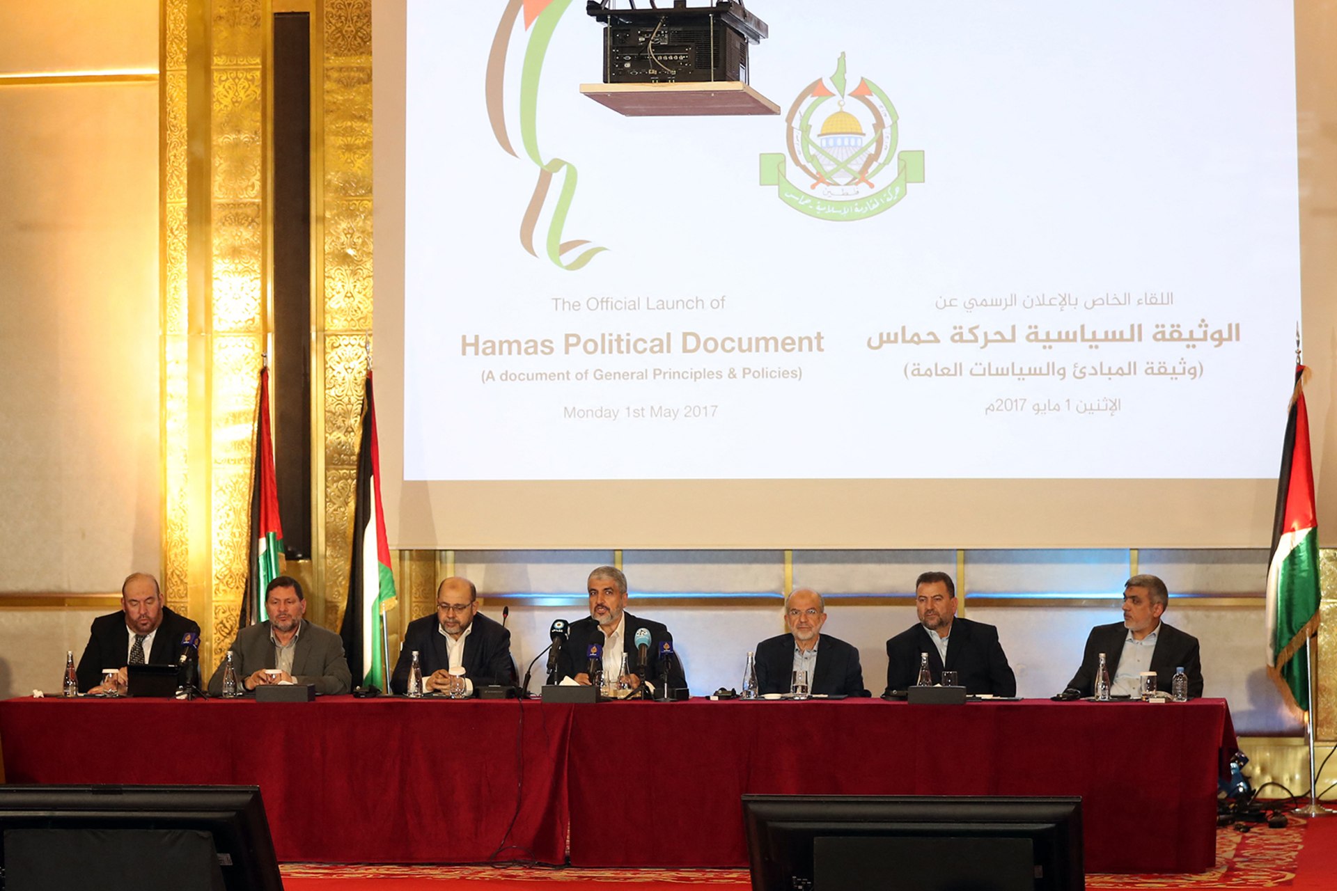 A panel of men sits in front of a projected screen that reads, "The Official Launch of Hamas Political Document (A document of General Principles & Policies).