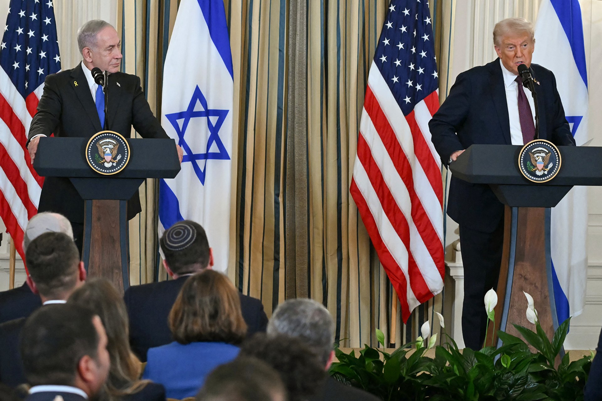 U.S. President Donald Trump and Israeli Prime Minister Benjamin Netanyahu stand at podiums and participate in a press conference in the State Dining Room of the White House.