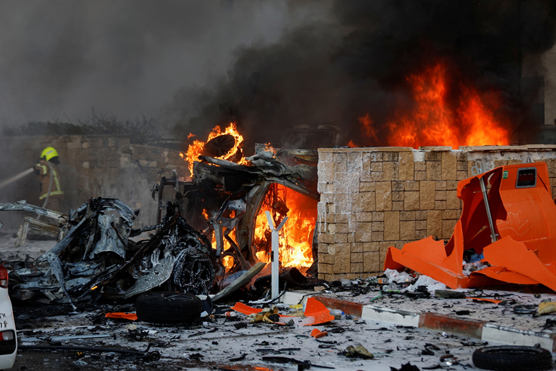 Vehicles and other objects are seen burning on a road.