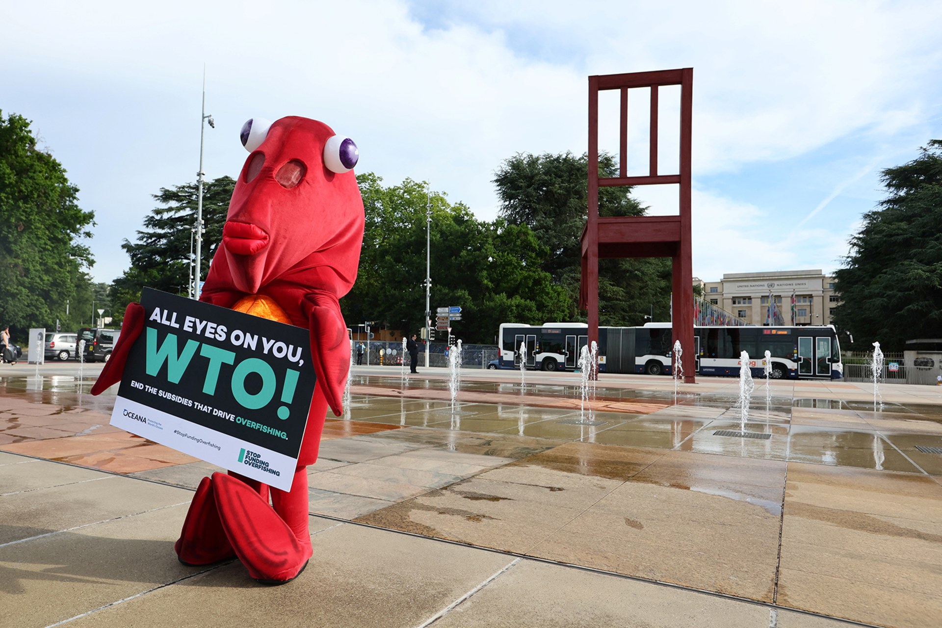 A person in a red fish costume stands holding a sign saying "All eyes on you, ETO! End the subsidies that drive overfishing".