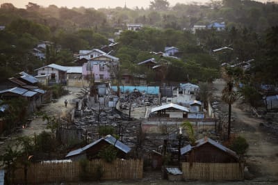 A woman walks past a burnt Islamic school in Meikhtila.