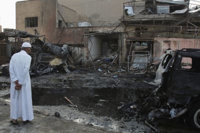 A man inspects the site a day after a bomb attack in Baghdad.