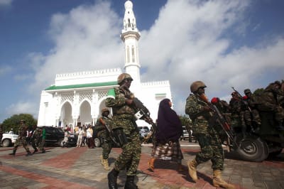 Soldiers serving in the African Union Mission in Somalia patrol outside a Mosque. 
