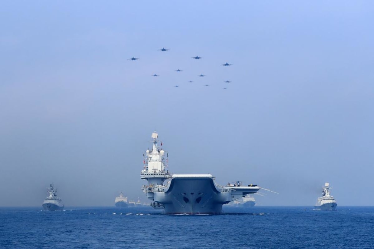 Chinese warships and fighter jets take part in a military display in the South China Sea on April 12, 2018. 