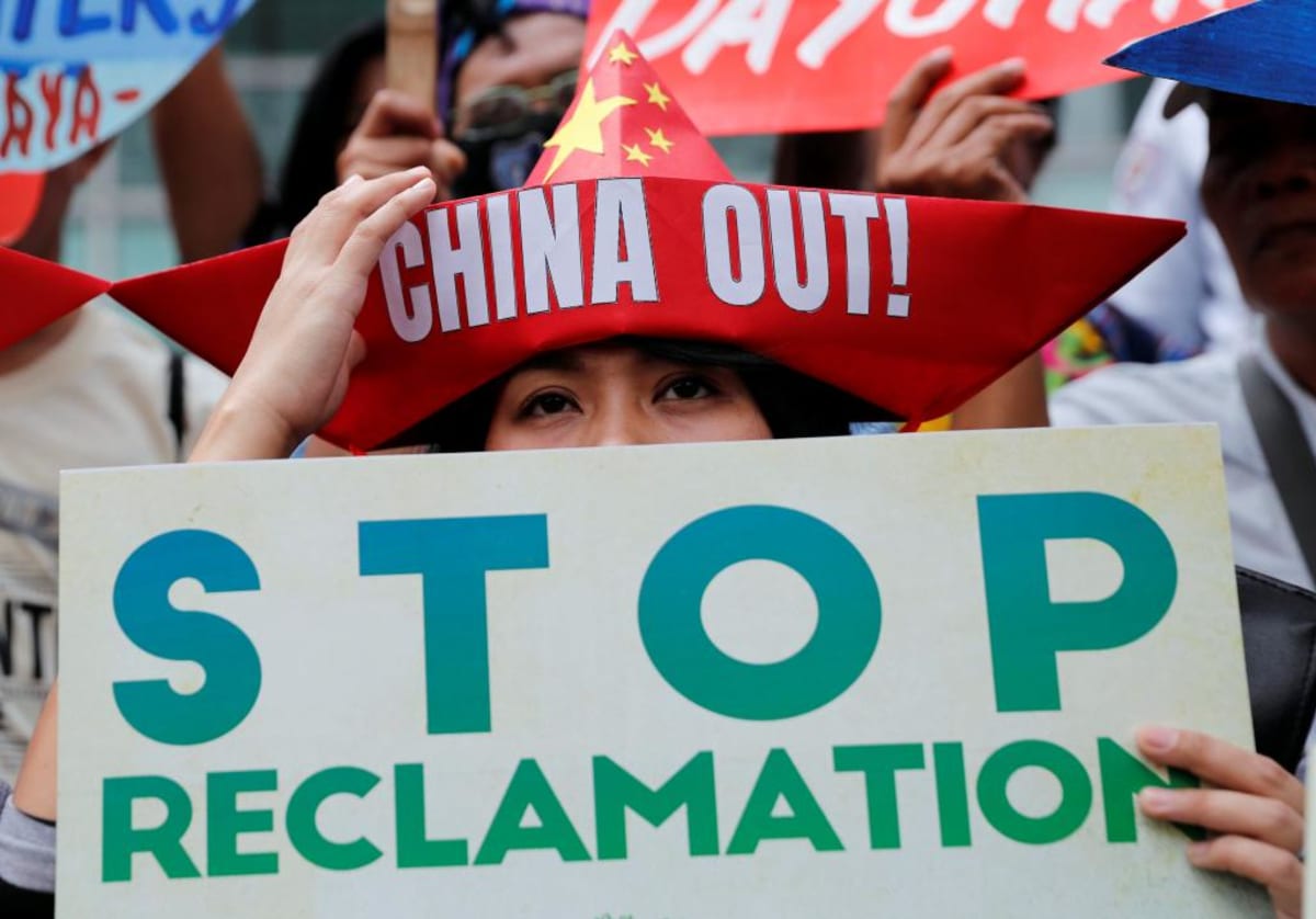 Protestors display placards during a rally outside the Chinese Consulate in Makati, the Philippines, to protest China's reclamation activities in the South China Sea on February 10, 2018. 