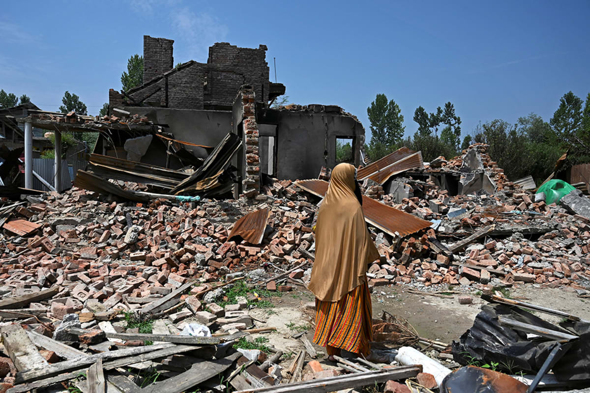A women inspects the rubble of her relatives’ houses, which were destroyed by mortars during a firefight between Indian soldiers and rebels north of Srinagar, on July 30, 2020.