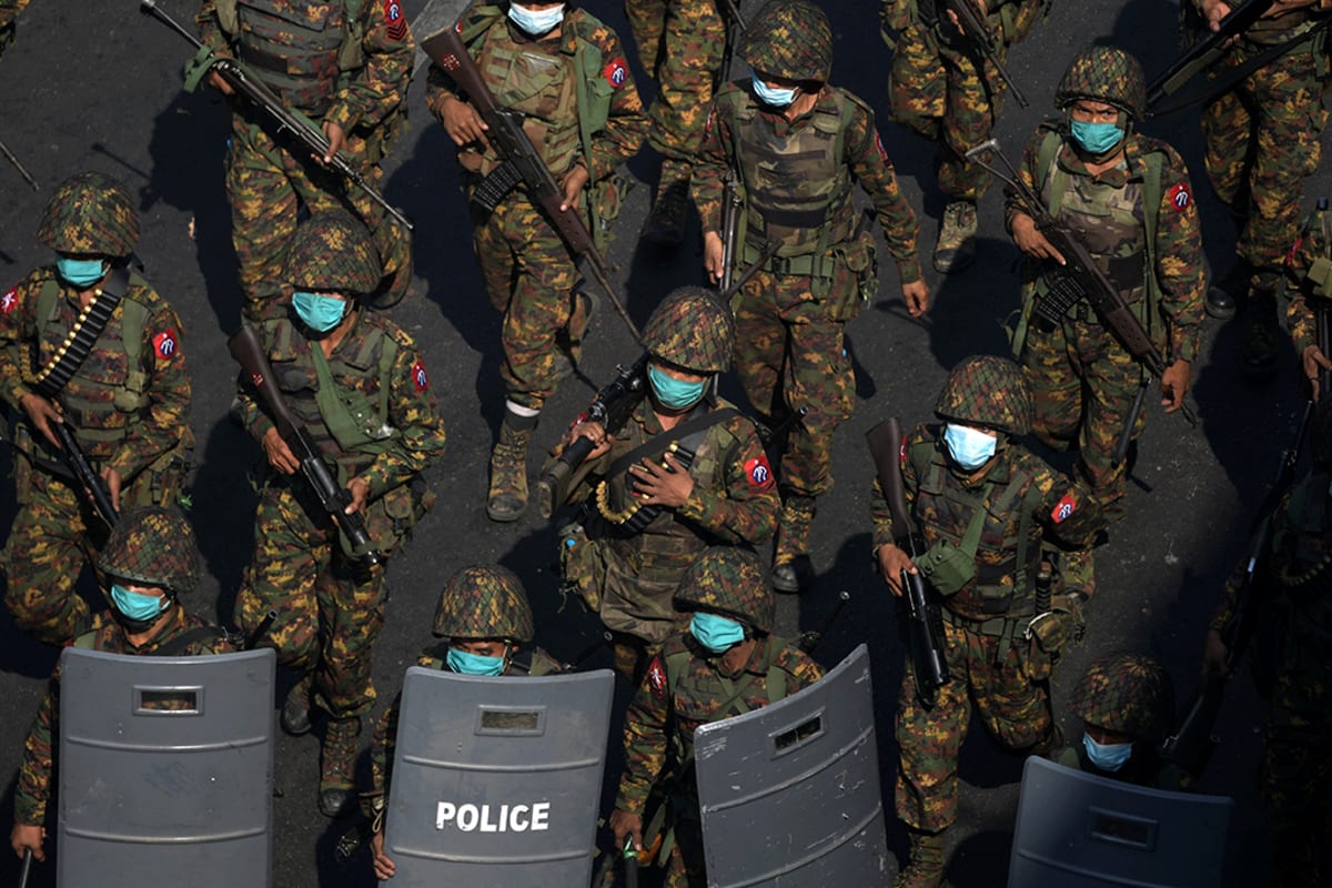 Myanmar soldiers from the 77th light infantry division walk along a street