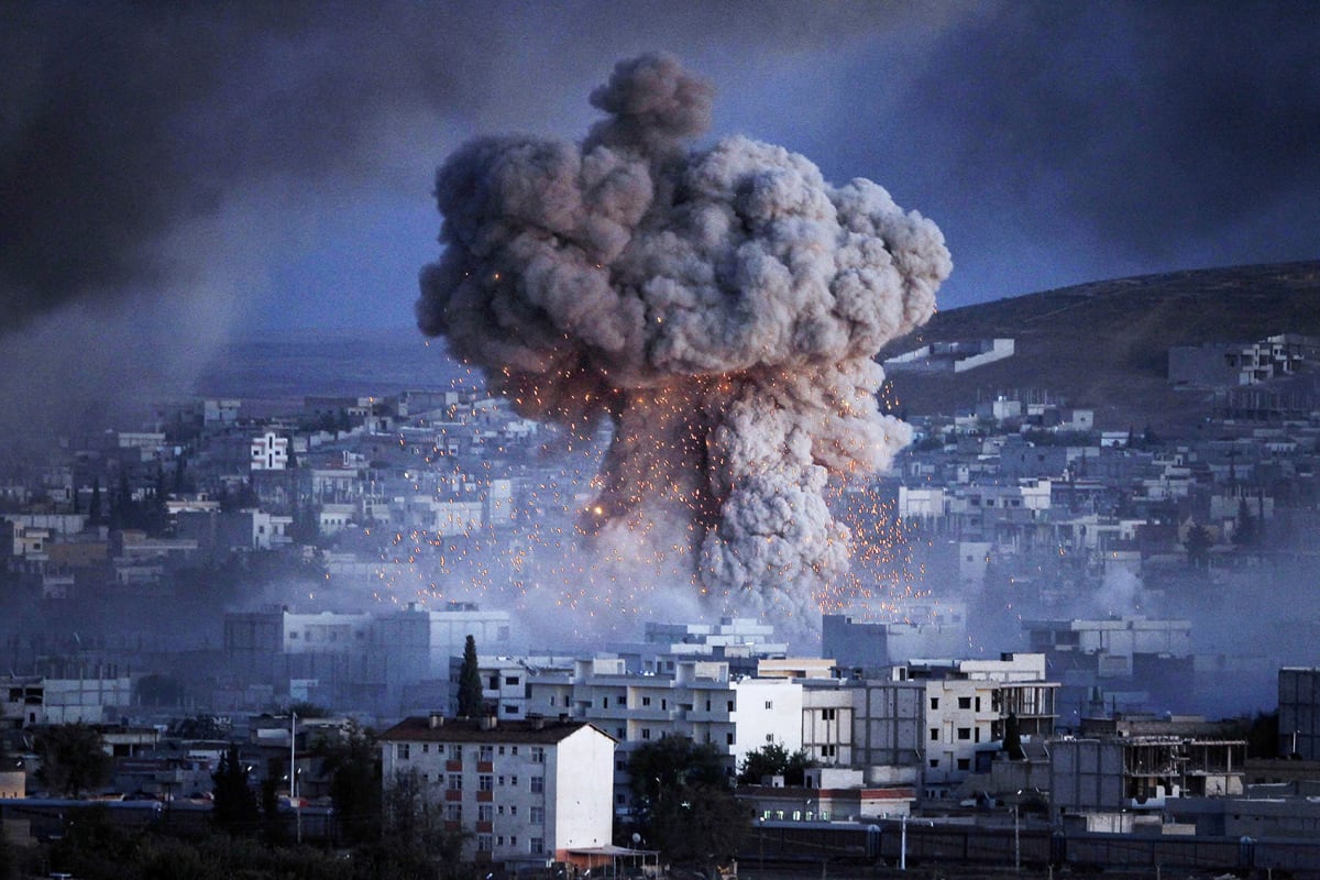 An explosion rocks the Syrian town of Kobani during a reported suicide car bomb attack by Islamic State militants on a People’s Protection Unit (YPG) position in the city center of Kobani, as seen from the outskirts of Suruc, on the Turkey-Syria border, on October 20, 2014. 