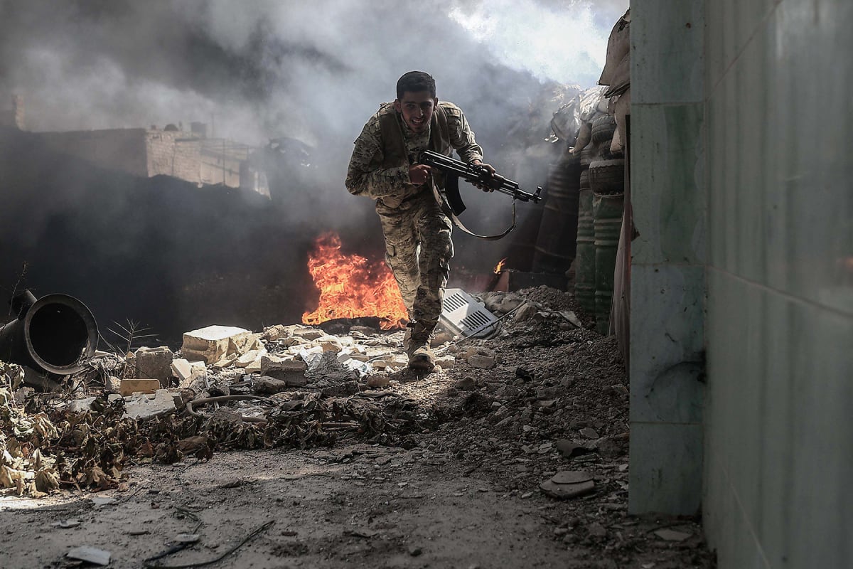 A fighter from the Jaish al-Islam runs to avoid sniper fire, in the village in the Tal al-Siwan area of the rebel-held stronghold of Douma, on the outskirts of Damascus, on September 5, 2016. 