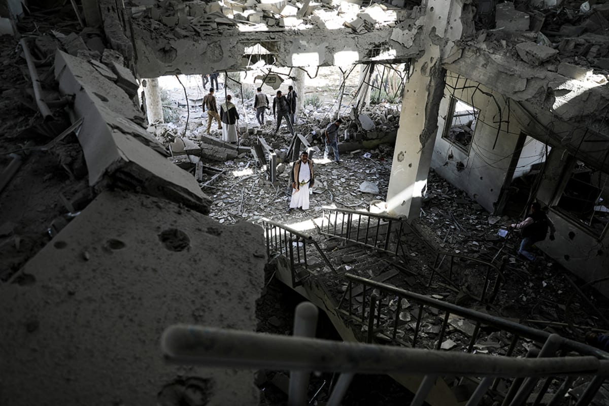 Security guards and journalists inspect the site of a Saudi-led airstrike on a telecommunication station in Sana’a, Yemen, on February 14, 2022.