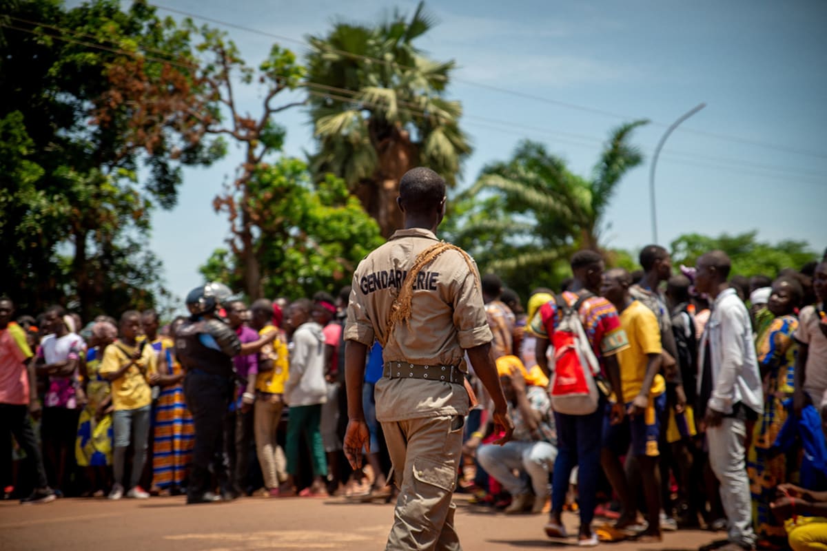 A guard watches over a large crowd of people.